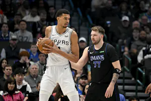 San Antonio Spurs center Victor Wembanyama (1) looks to move the ball past Dallas Mavericks guard Luka Doncic (77), as we examine the NBA MVP opening odds with early predictions and expert picks.