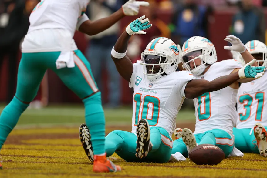 Wide receiver Tyreek Hill #10 of the Miami Dolphins celebrates as we look at the NFL Week 14 odds & betting lines.