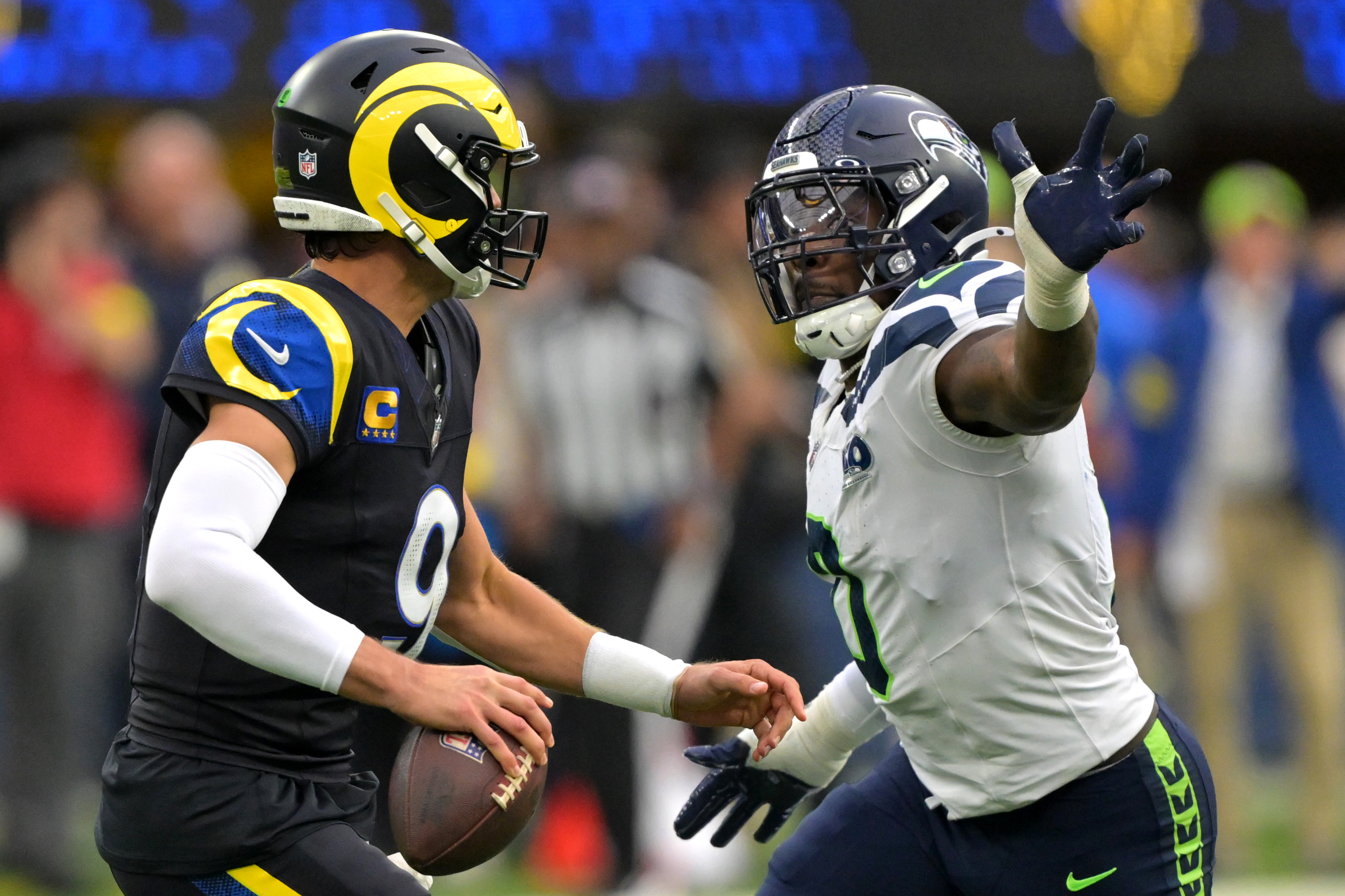 Matthew Stafford is pressured by linebacker DeMarcus Lawrence as we offer our Rams vs. Seahawks prediction.
