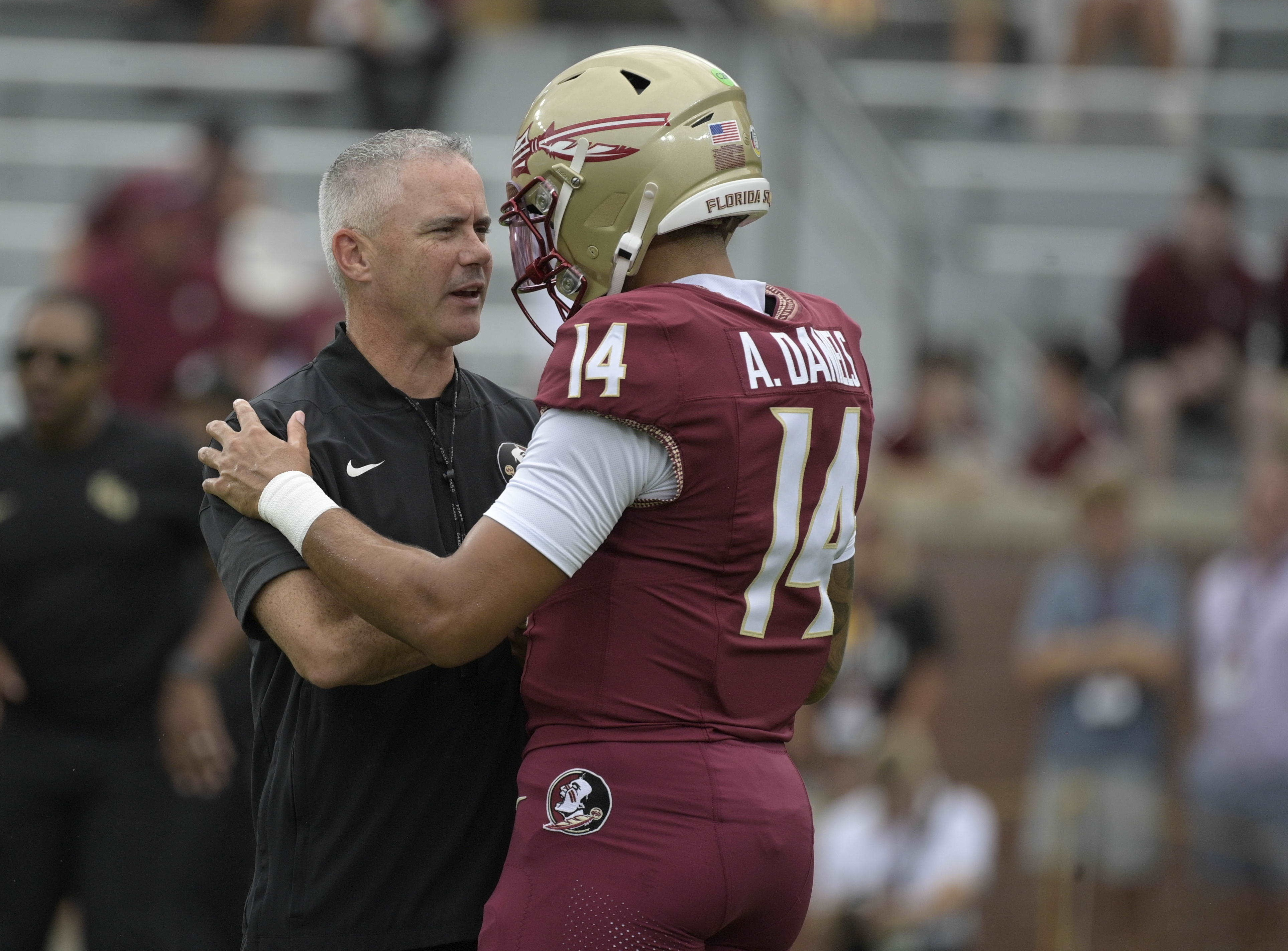 Florida State head coach Mike Norvell talks with quarterback Ashton Daniels (14) as we break down our SMU vs. Florida State prediction.