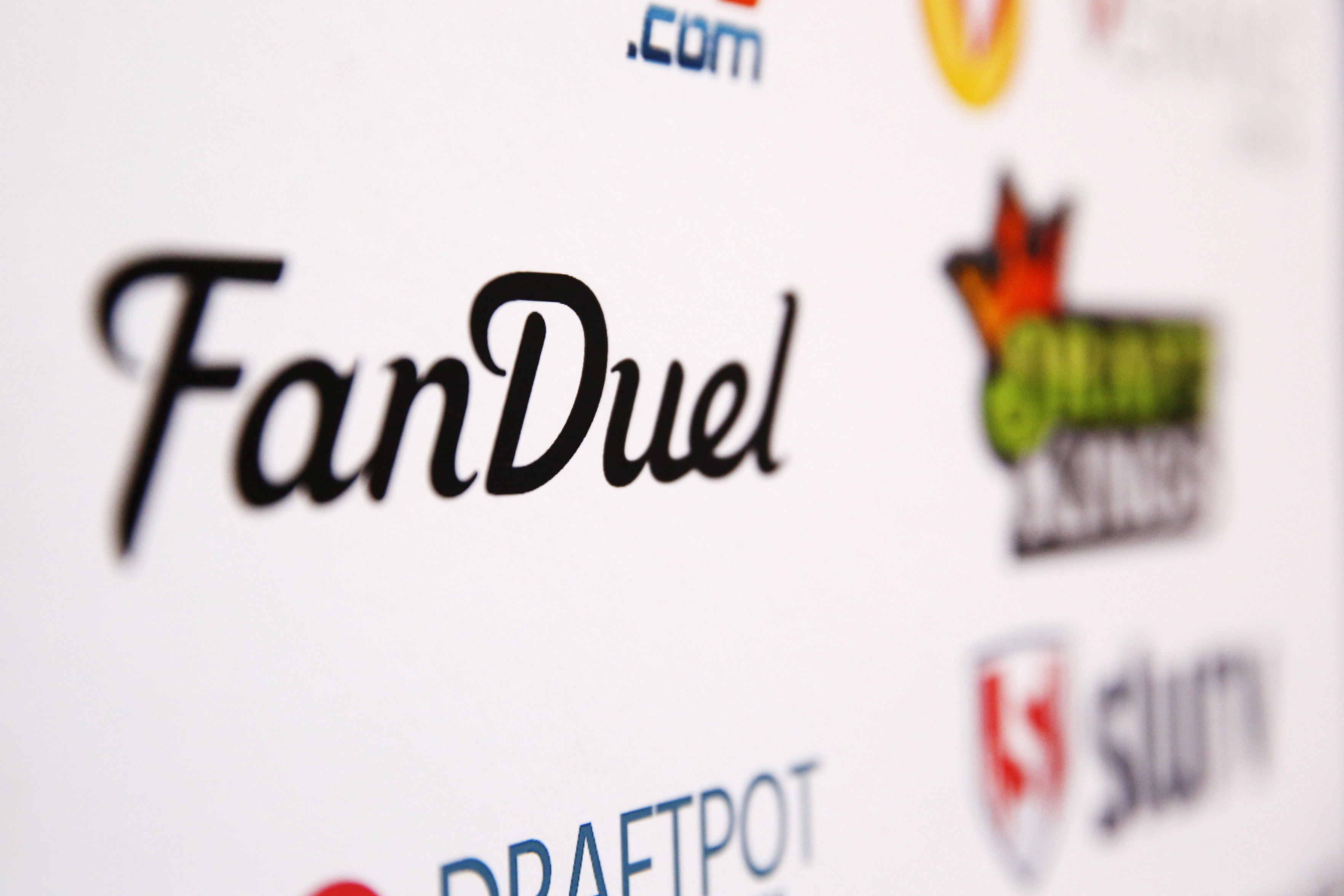 A FanDuel logo is displayed on a board, as we look at a gambling addiction lawsuit against FanDuel and DraftKings