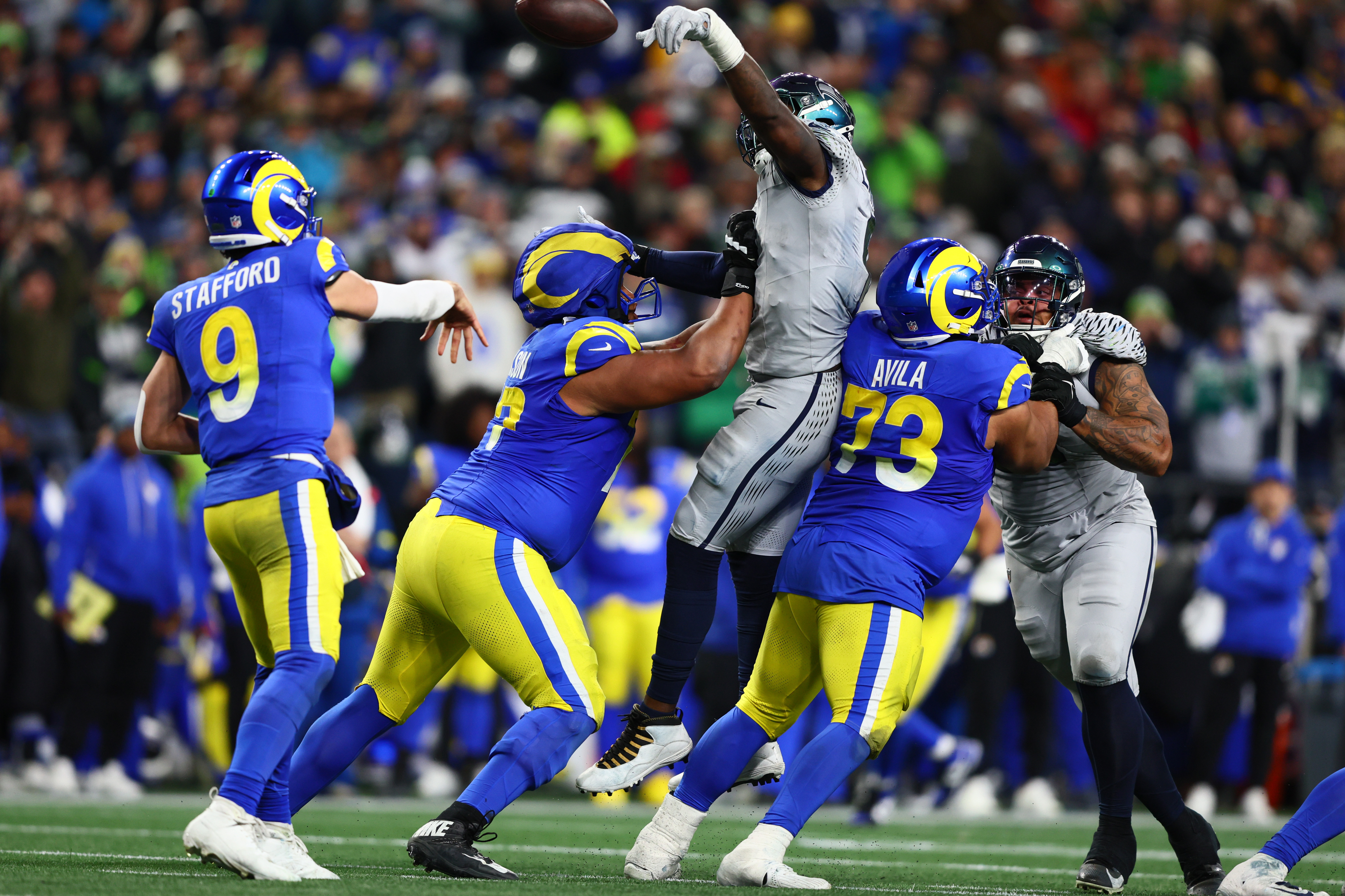 Seattle Seahawks defensive end Demarcus Lawrence blocks a pass by Los Angeles Rams quarterback Matthew Stafford as we offer our NFL conference championship predictions.