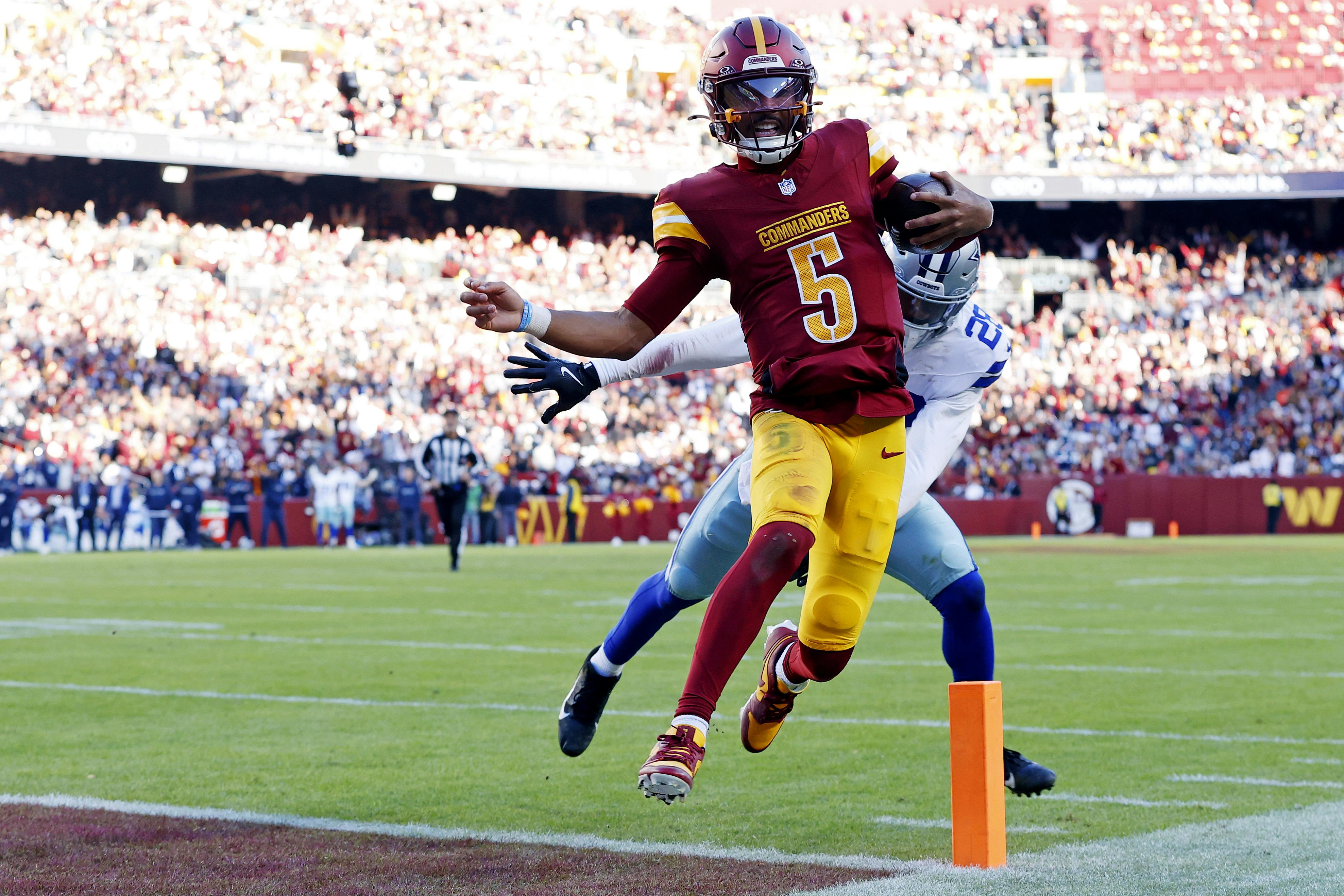 Washington Commanders quarterback Jayden Daniels runs for a touchdown against Dallas Cowboys safety Malik Hooker, and he