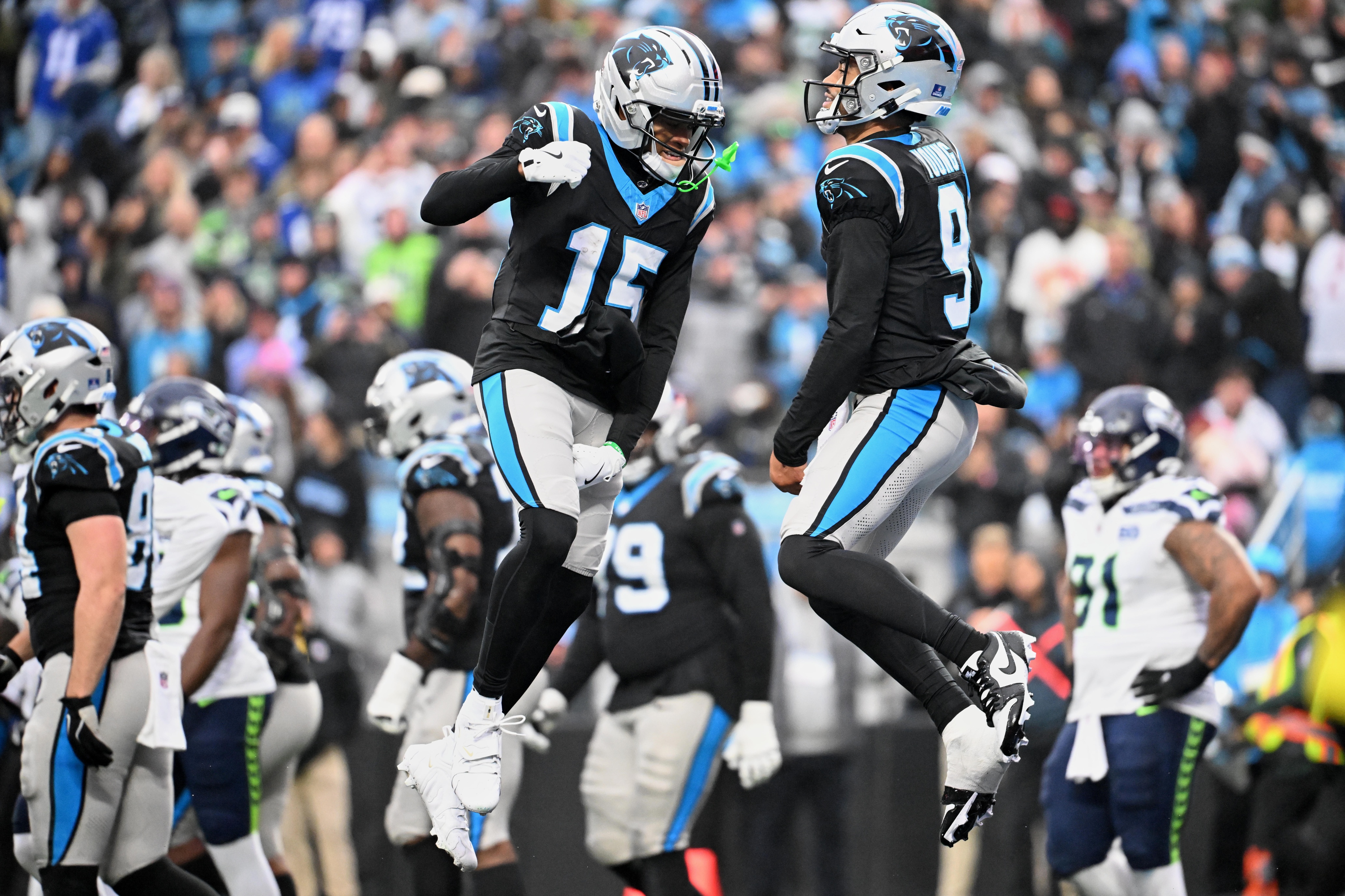 Carolina Panthers quarterback Bryce Young - who's featured in my Panthers vs. Buccaneers prediction - leaps and celebrates with wide receiver Jimmy Horn Jr. (15) after scoring a touchdown. 
