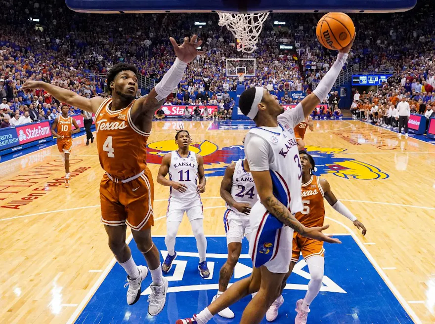 Dajuan Harris Jr. #3 of the Kansas Jayhawks shoots a layup against Tyrese Hunter #4 and Marcus Carr #5 of the Texas Longhorns. We discuss who wins the regular-season finale in our Kansas vs. Texas picks.