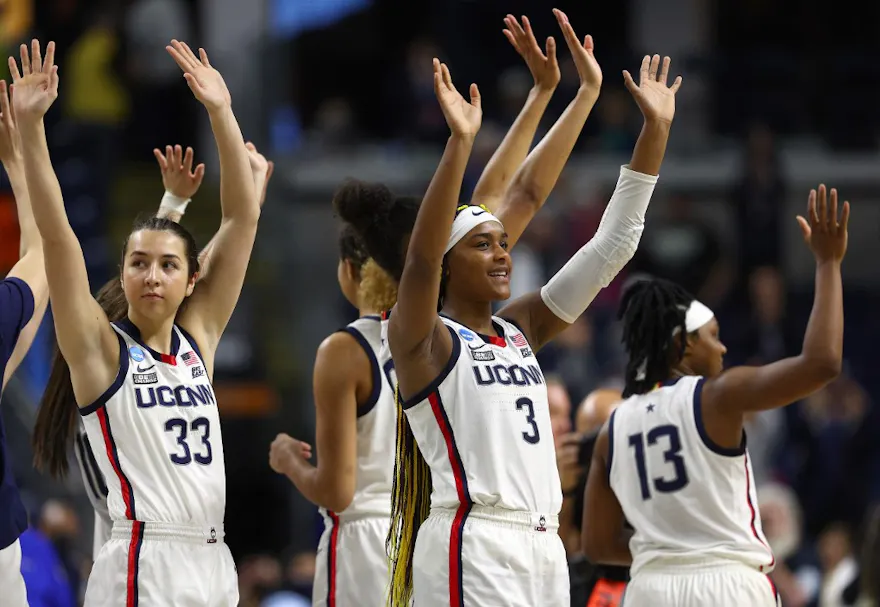 Caroline Ducharme, Aaliyah Edwards, and Christyn Williams of the UConn Huskies salute the fans after the game against the Indiana Hoosiers during the Sweet Sixteen as we look at Fanatics replacing Rush Street interactive.