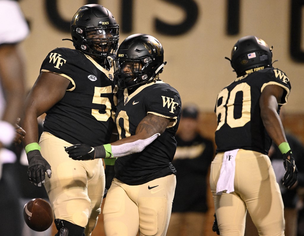 Christian Turner and Loic Ngassam Nya of the Wake Forest Demon Deacons celebrate Turner's third quarter touchdown against the Army Black Knights at Truist Field on October 08, 2022 in Winston-Salem, North Carolina. Photo by Eakin Howard/Getty Images via AFP.