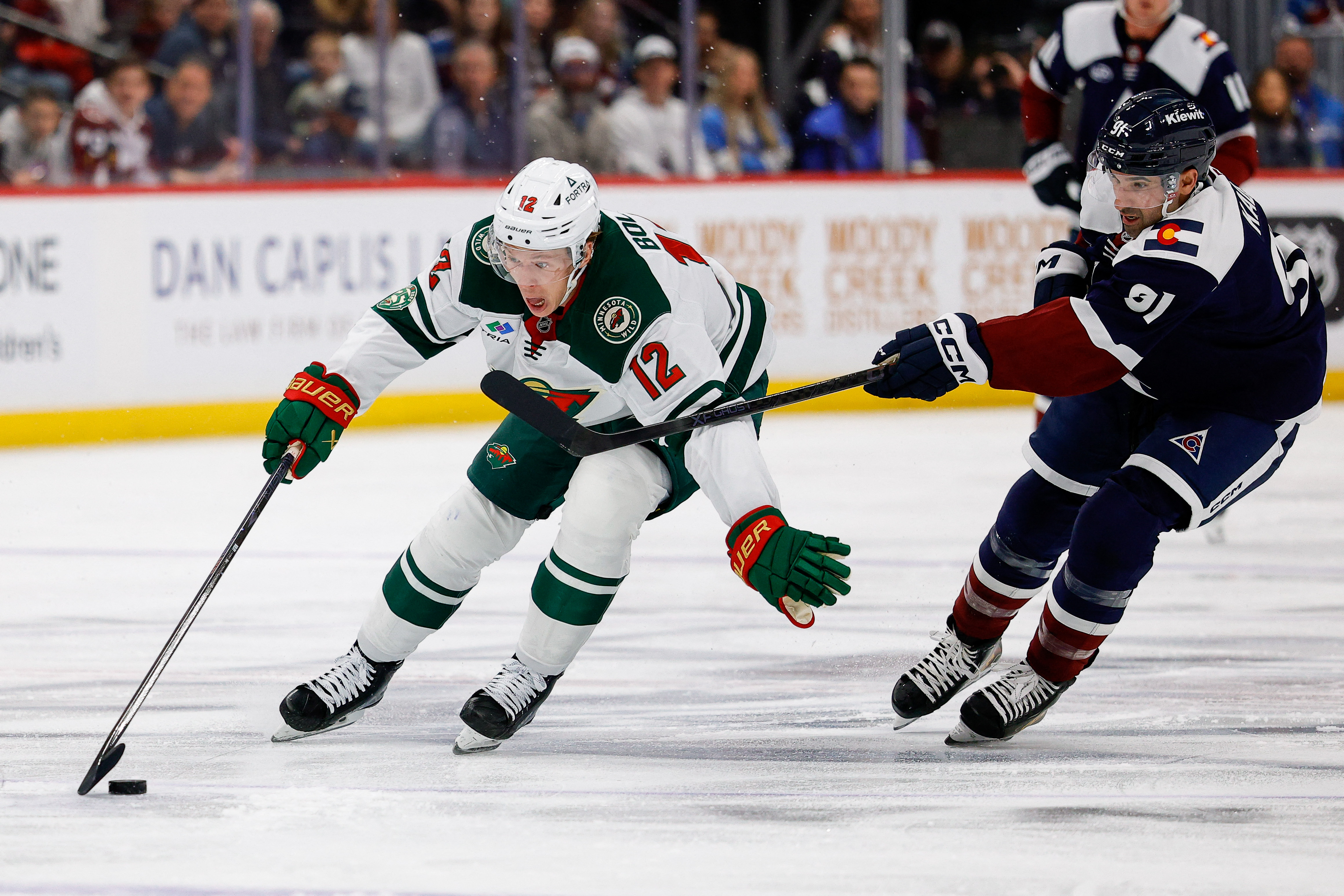 Minnesota Wild winger Matt Boldy (12) controls the puck ahead of Colorado Avalanche forward Nazem Kadri (91) as we provide our Wild vs. Avalanche Game 1 prediction.