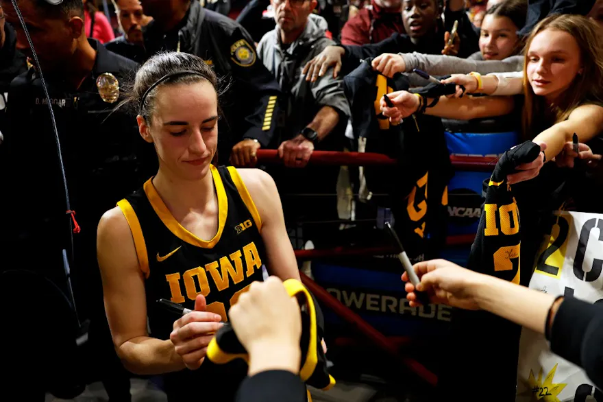 Caitlin Clark of the Iowa Hawkeyes signs autographs for fans after the game against the Minnesota Golden Gophers, and we offer our top Ohio State vs. Iowa predictions based on the best NCAAB odds.