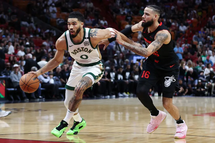 Jayson Tatum #0 of the Boston Celtics drives against Caleb Martin #16 of the Miami Heat as we look at our Heat vs. Celtics Game 1 NBA player props